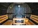 Relaxing home sauna featuring wooden benches, a stove, and wood paneling for a traditional spa experience at 5370 Whispering Pine Cir, St Cloud, FL 34771