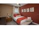 Inviting bedroom with warm red accents, plush bedding, and natural light from the window at 7546 Headwaters Ct, Groveland, FL 34736