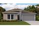 Charming single-story home features a two-car garage, manicured lawn, and thoughtfully designed front elevation at 7546 Headwaters Ct, Groveland, FL 34736