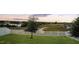 Lush backyard with green grass, privacy fence, and a serene view of the lake and distant landscape at 818 Kapi Dr, Groveland, FL 34736