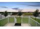 Spacious backyard view with white fence and tranquil scenery of a lake and surrounding green space at 818 Kapi Dr, Groveland, FL 34736