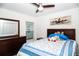 Cozy bedroom featuring a ceiling fan, a wooden dresser, and a queen bed with blue and white patterned bedding at 818 Kapi Dr, Groveland, FL 34736