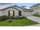 Single-story home with a manicured lawn, two-car garage, and charming curb appeal at twilight at 818 Kapi Dr, Groveland, FL 34736