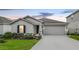 Charming single-story home featuring a well-maintained lawn and attached two-car garage at 818 Kapi Dr, Groveland, FL 34736