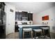 Bright kitchen with black cabinets, a large island with seating, and stainless steel appliances at 818 Kapi Dr, Groveland, FL 34736