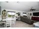 Open-concept living room with neutral decor, tile flooring, and sliding glass doors to the outdoors at 818 Kapi Dr, Groveland, FL 34736