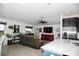 Open-concept living room featuring a gray sofa, a red entertainment center, and a kitchen island at 818 Kapi Dr, Groveland, FL 34736