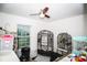 Room featuring two large birdcages, a ceiling fan, and a window allowing natural light at 818 Kapi Dr, Groveland, FL 34736