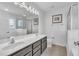 Bathroom featuring a double sink vanity, large mirror with vanity lighting, and a glass door shower at 9189 Camden Gardens St, Orlando, FL 32827