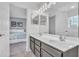 Bathroom featuring a double sink vanity with a view into a bedroom with a blue accent wall at 9189 Camden Gardens St, Orlando, FL 32827