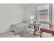 Bright bedroom features a twin bed, a desk with chair, and a window with blinds at 9189 Camden Gardens St, Orlando, FL 32827