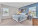 Primary bedroom featuring a blue accent wall, floral bedding, and two large windows at 9189 Camden Gardens St, Orlando, FL 32827
