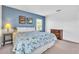 Primary bedroom featuring blue accent wall, floral bedding, two windows, and a wooden dresser at 9189 Camden Gardens St, Orlando, FL 32827