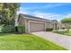 Attached two-car garage with brick-paved driveway and manicured lawn at 9189 Camden Gardens St, Orlando, FL 32827