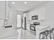 Bright, all-white kitchen with stainless steel appliances, marble tile flooring, and breakfast bar at 9189 Camden Gardens St, Orlando, FL 32827