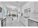 Open-concept kitchen featuring all-white cabinets and marble tile flooring with view to dining and living rooms at 9189 Camden Gardens St, Orlando, FL 32827