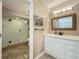 A peek into a well-lit bathroom reveals a glass shower and vanity with white cabinets at 103 Red Cedar Dr, Longwood, FL 32779