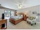 Bright bedroom with a wood bed frame and light tan colored decor with access to the rear patio at 103 Red Cedar Dr, Longwood, FL 32779