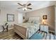 Bright bedroom featuring a wooden bed frame, floral bedding, ceiling fan, and wood-look flooring at 103 Red Cedar Dr, Longwood, FL 32779