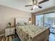 Cozy bedroom with floral bedding, patio access, wood-look flooring, and a ceiling fan at 103 Red Cedar Dr, Longwood, FL 32779
