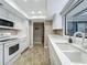 Galley style kitchen with sleek white appliances and countertops, offering a clean and modern feel at 103 Red Cedar Dr, Longwood, FL 32779