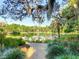 Beautiful pond view featuring lush gardens, mature trees, manicured green spaces, and serene water at 103 Red Cedar Dr, Longwood, FL 32779