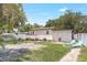 Wide backyard with a sun-bathing area and a wooden porch connected to the house in the back at 1032 Perkins Rd, Orlando, FL 32809