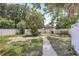 Spacious backyard featuring a patio, lush greenery, and a secure fence at 1032 Perkins Rd, Orlando, FL 32809