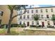Three story townhouse with a landscaped front yard with a walkway to the front door at 1038 Waterside Dr, Celebration, FL 34747