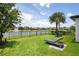 Lush backyard with lounge chair, outdoor seating, and serene lake view featuring a fountain, perfect for relaxation at 10529 Royal Cypress Way, Orlando, FL 32836