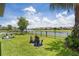 Inviting backyard with lounge chairs overlooking tranquil lake views and manicured lawn, perfect for outdoor relaxation at 10529 Royal Cypress Way, Orlando, FL 32836