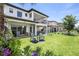 Expansive backyard with patio, outdoor kitchen, covered seating, pool, and lake views, perfect for entertaining at 10529 Royal Cypress Way, Orlando, FL 32836