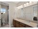 Spacious bathroom with a large mirror, double sinks, and a glass-enclosed shower at 10529 Royal Cypress Way, Orlando, FL 32836