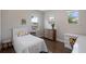 Cozy bedroom featuring a white bed, desk, dresser, and hardwood floors at 10529 Royal Cypress Way, Orlando, FL 32836