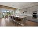 Open kitchen with gray cabinets, large center island, stainless steel appliances, and hardwood floors at 10529 Royal Cypress Way, Orlando, FL 32836