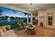 Evening view of a covered patio overlooking a scenic lake with a fountain and lounge furniture at 10529 Royal Cypress Way, Orlando, FL 32836