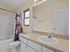 Well-lit bathroom featuring a toilet, shower with tub, a large mirror, and ample cabinet space at 1112 Winding Water Way, Clermont, FL 34714