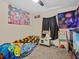 Cozy bedroom featuring colorful wall art, a playful bedspread, and a quirky toy kitchen set at 1112 Winding Water Way, Clermont, FL 34714