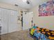 This carpeted bedroom has a spacious closet and is decorated with colorful wall art at 1112 Winding Water Way, Clermont, FL 34714