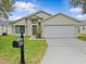 Inviting single-story home featuring a well-maintained lawn, neutral paint, and an attached two-car garage at 1112 Winding Water Way, Clermont, FL 34714