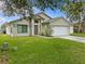 Charming single-story home boasting a manicured lawn, neutral stucco, and an attached two-car garage at 1112 Winding Water Way, Clermont, FL 34714