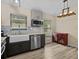 Well-lit kitchen featuring a farmhouse sink, stainless steel appliances and ample natural light from two windows at 1112 Winding Water Way, Clermont, FL 34714