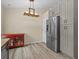 Bright kitchen area featuring stainless steel appliances, contemporary lighting, and durable laminate flooring at 1112 Winding Water Way, Clermont, FL 34714