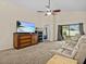 Comfortable living room showcasing plush seating, entertainment center, ceiling fan, and sliding glass doors at 1112 Winding Water Way, Clermont, FL 34714