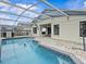 View of the pool, patio and the exterior of the home; the patio has an outdoor tv and ceiling fan at 1112 Winding Water Way, Clermont, FL 34714