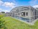 This outdoor pool area features a screened enclosure, and a well maintained lawn area at 1112 Winding Water Way, Clermont, FL 34714