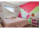 Charming bedroom featuring a pink and green geometric painted wall and a window view at 11836 Hartfordshire Way, Orlando, FL 32824