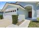 Close-up of home's entrance featuring an attached garage and red front door at 11836 Hartfordshire Way, Orlando, FL 32824