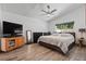 Spacious main bedroom featuring a ceiling fan, a large window and wood plank floors at 11836 Hartfordshire Way, Orlando, FL 32824