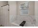Bright bathroom with a tub and a window for natural light and elegant marble-look tile at 146 E 15Th St, Apopka, FL 32703